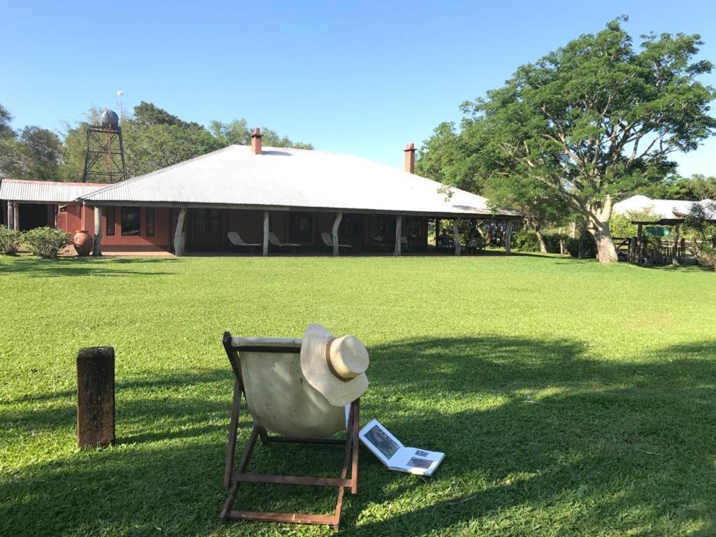 a hat sitting on top of a chair in a field at Rancho de los Esteros in Colonia Carlos Pellegrini