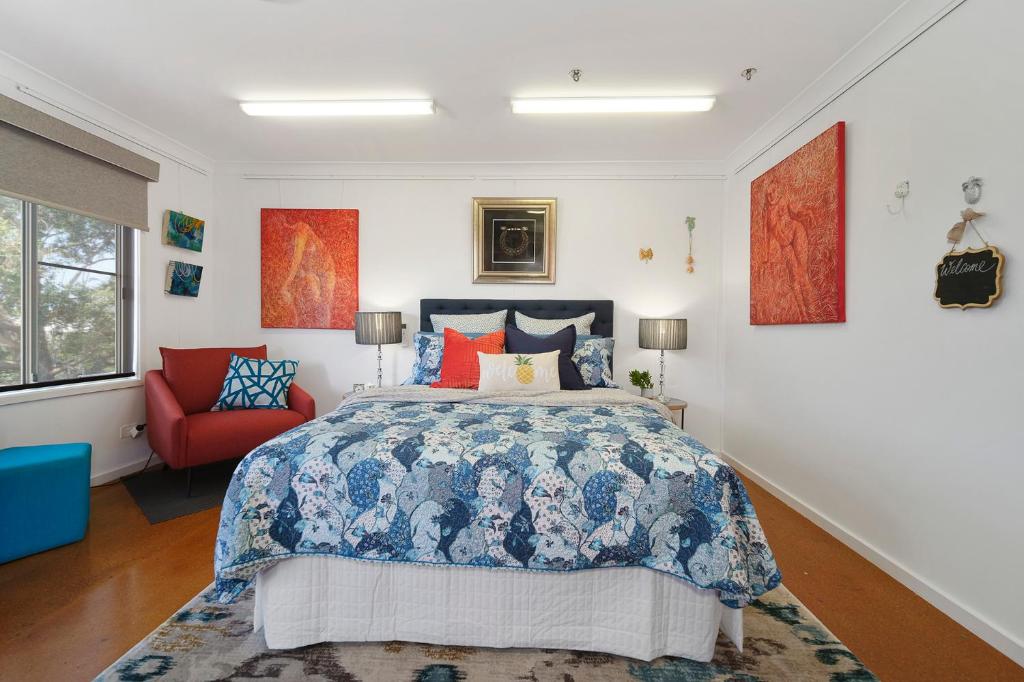 a bedroom with a bed and a red chair at Marche Home Stay, Immaculate Presentation, Private & Relaxing in Lambton