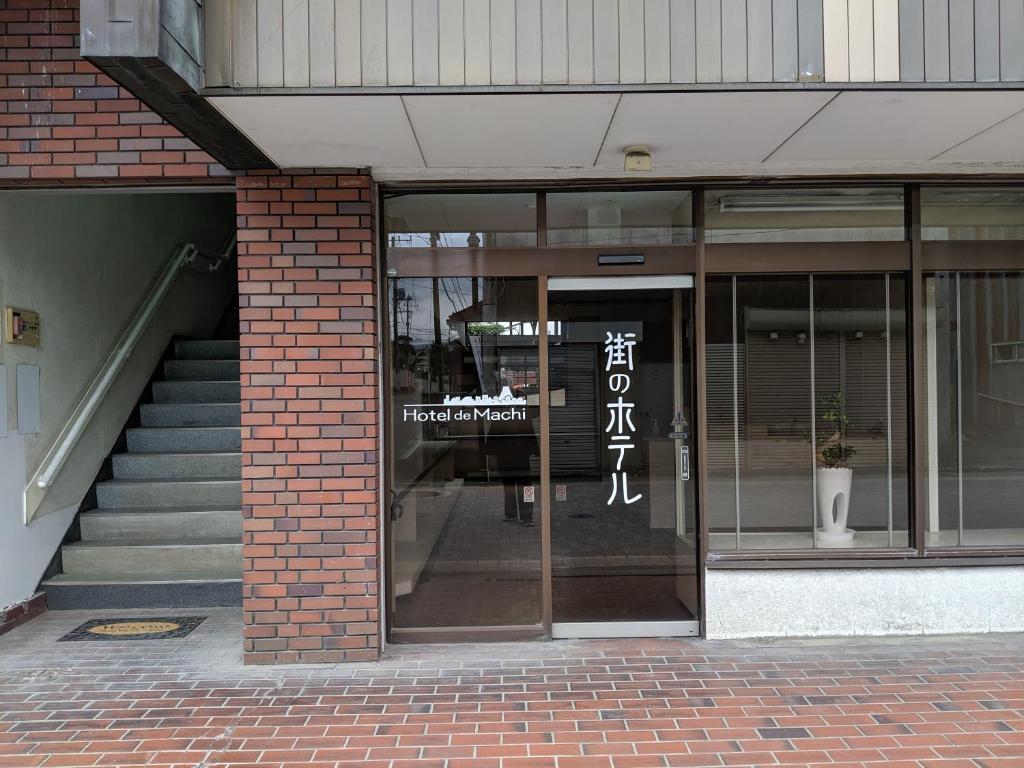 einen Eingang zu einem Gebäude mit einer Glastür in der Unterkunft 街のホテル in Fujiyoshida