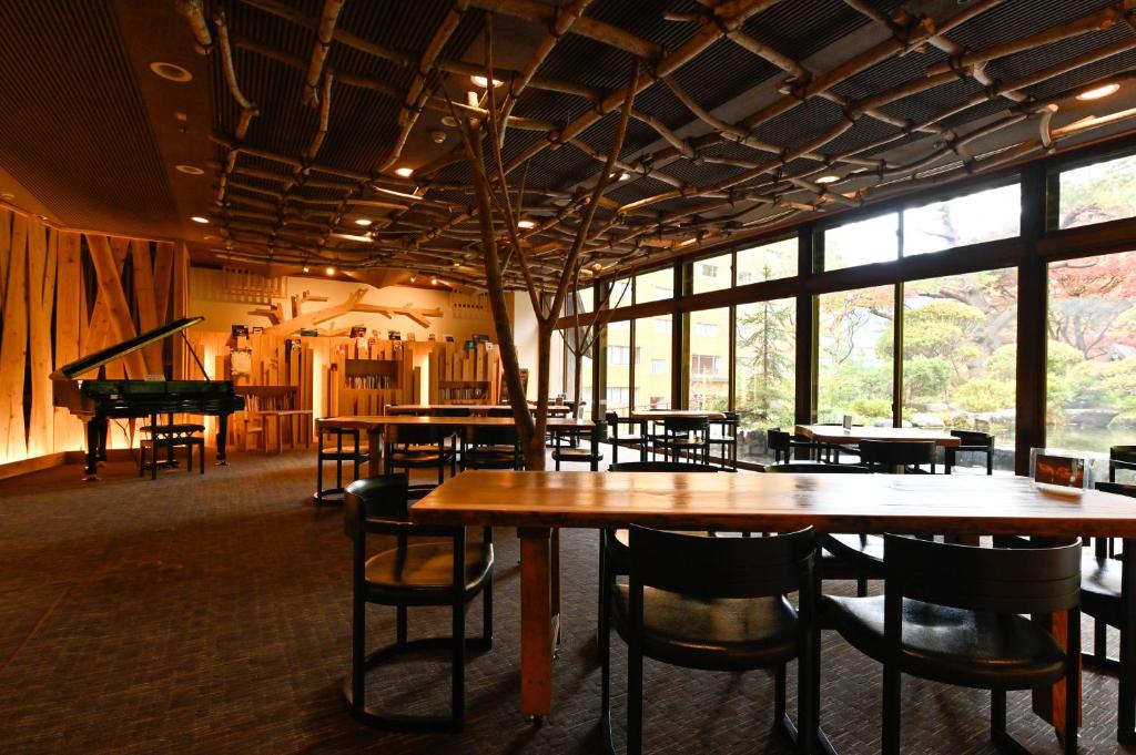 um restaurante com mesas e cadeiras e um piano em Yuze Hotel em Kazuno