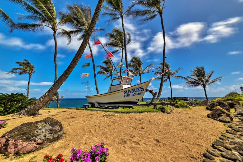 a boat on the beach with palm trees at Condo with Lanai at Beginning of Road to Hana! in Paia
