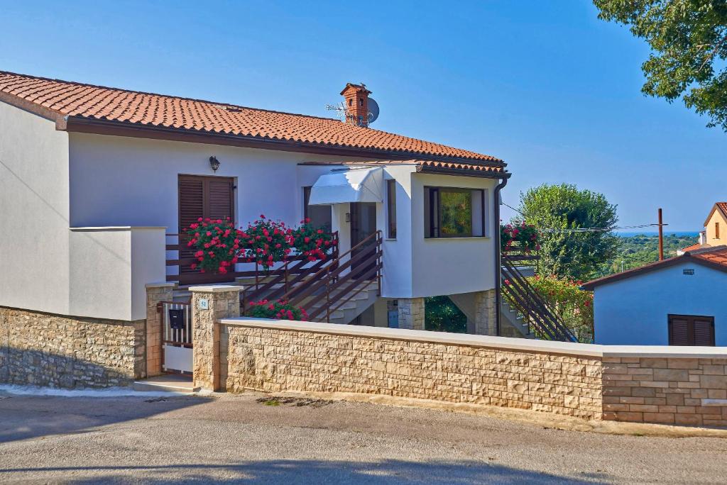 a white house with a brick retaining wall at Munat in Ližnjan * Istrien in Ližnjan