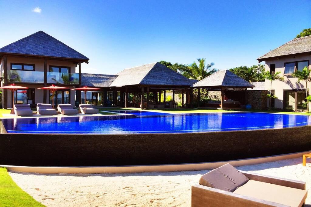 a swimming pool in front of a villa at Villa Takali - CFC Certified in Pacific Harbour