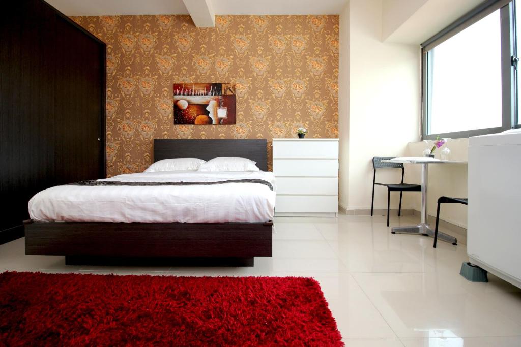 a bedroom with a bed and a red rug at JJH Serviced Apartments near Serangoon MRT in Singapore