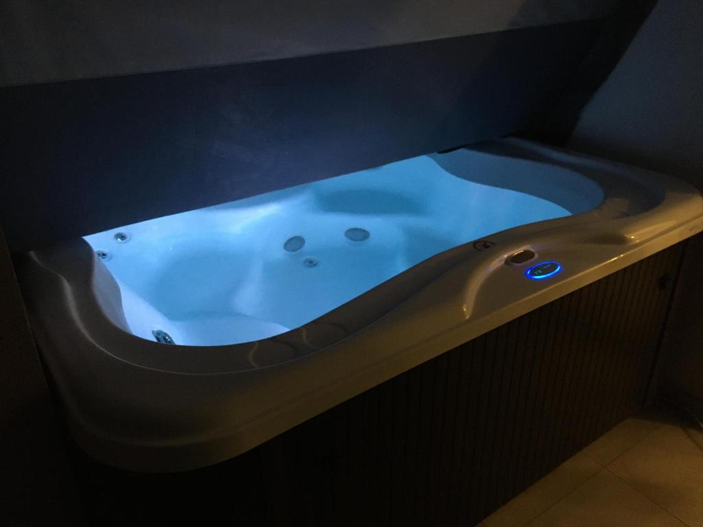 a bath tub in a room with a dark room at Apartment Electro with Jacuzzi in Novalja
