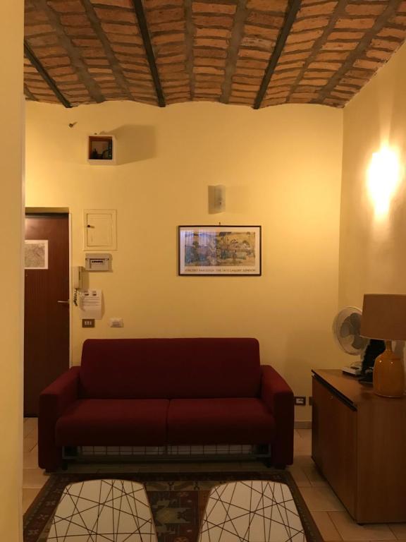 uma sala de estar com um sofá vermelho num quarto em A Ca Degli Equi B&B em Roma