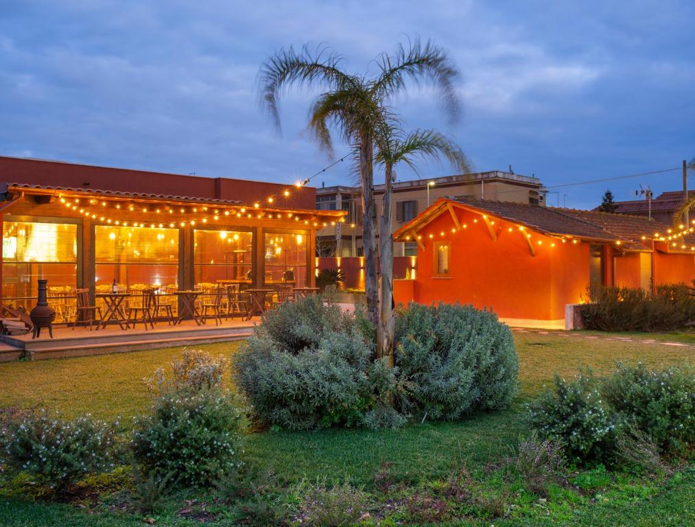 un edificio con una palmera y luces en él en Domus Porto Di Traiano Resort, en Fiumicino