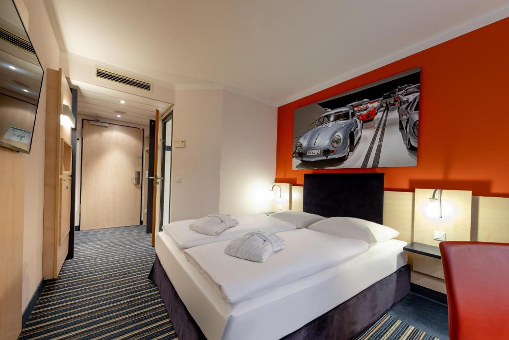 1 dormitorio con 1 cama y una foto de coche en Mercure Stuttgart City Center, en Stuttgart