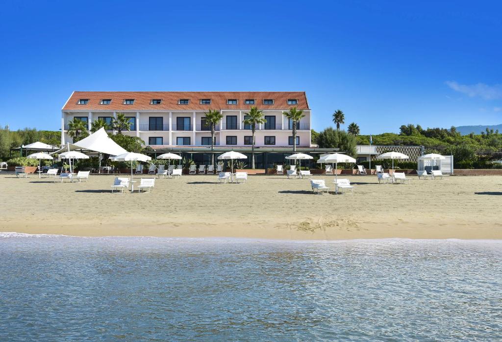 a beach with chairs and umbrellas in front of a hotel at Hotel Schuhmann in Paestum