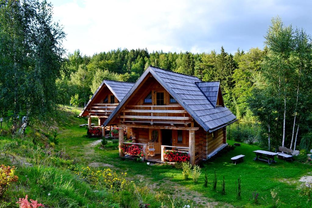 a log cabin in the woods with a solar roof at Leśniówka Domki W Karpaczu in Karpacz