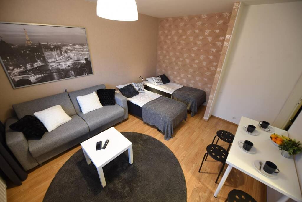 uma sala de estar com um sofá e uma mesa em Rental Apartment Kupittaa Suomen Vuokramajoitus Oy em Turku