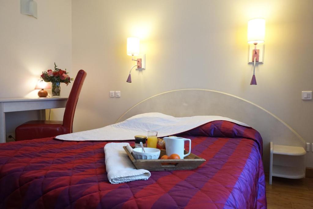 bandeja de comida en una cama en una habitación de hotel en Hotel Le Progrés Dorlotel, en Le Mont-Dore