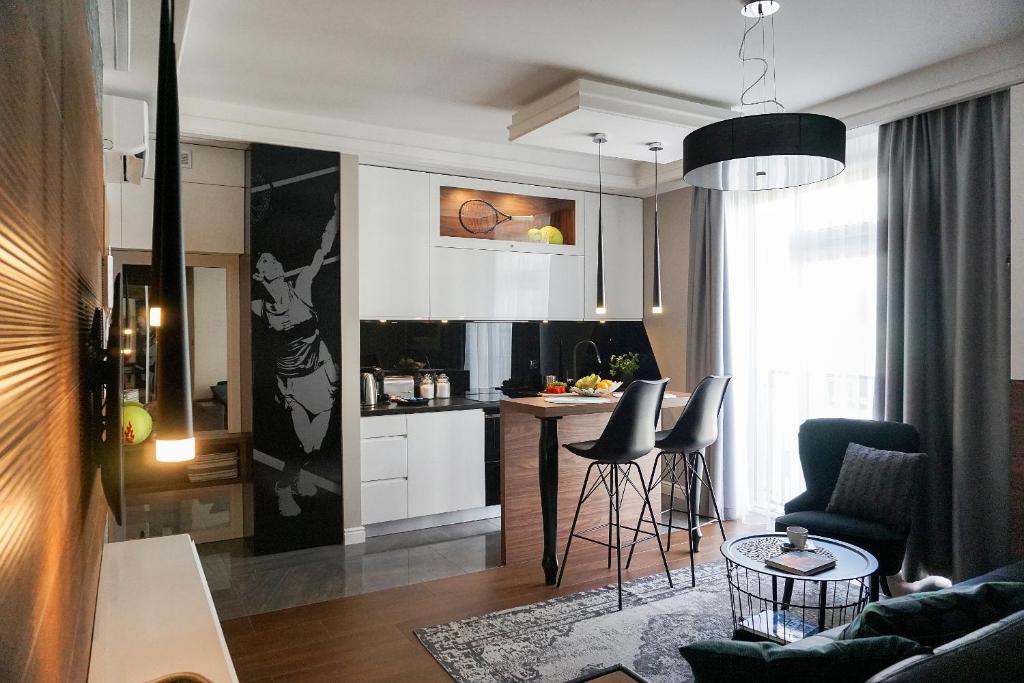 kuchnia i salon ze stołem i krzesłami w obiekcie AGA Tenis Apartments by Radwańska w Krakowie
