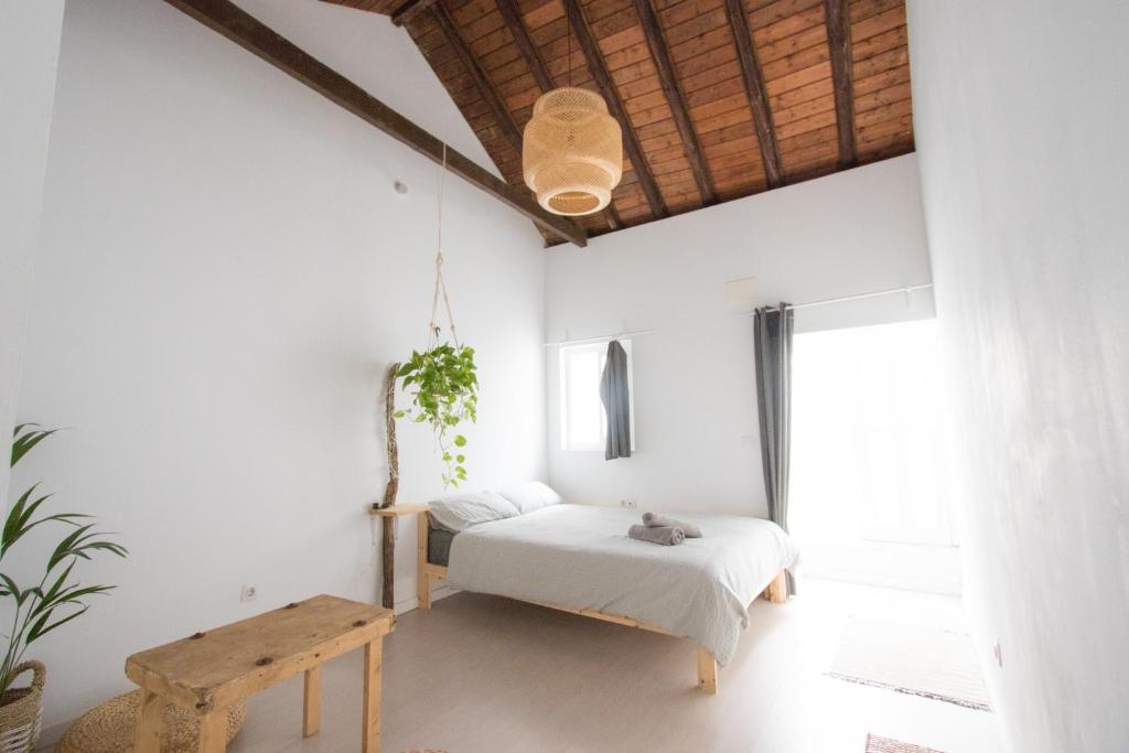 um quarto com uma cama e uma mesa de madeira em Casa Calma Yoga Guesthouse em Agaete