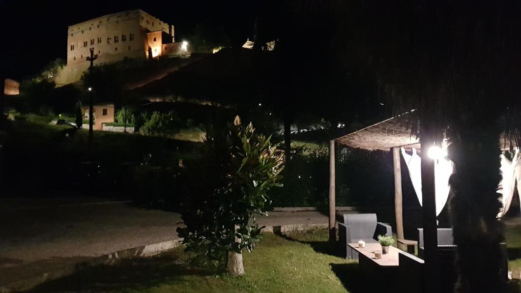 Blick auf ein Gebäude mit einem Tisch und einem Baum in der Unterkunft VAL D'ORCIA DELUXE 2, RAFFINATA CASA immersa nel verde con WiFi, giardino e parcheggio in Montalcino