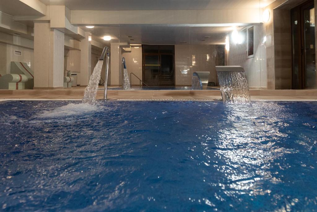 une grande piscine d'eau dans un bâtiment dans l'établissement Zornica Hotel, à Kazanlak