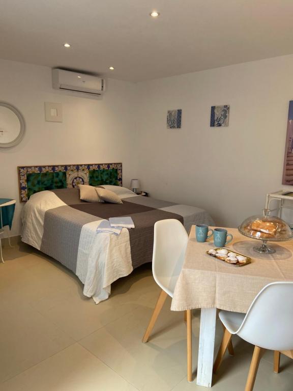 Schlafzimmer mit einem Bett, einem Tisch und Stühlen in der Unterkunft Casa vacanze Al porticciolo romantico in Trappeto