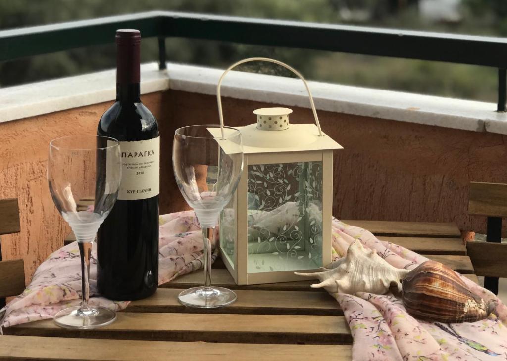 a bottle of wine and two glasses on a table at Dimitra’s and Nasia’s Villa in Psakoudia