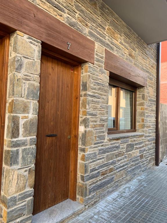 eine Holztür an der Seite eines Steingebäudes in der Unterkunft Apartameto Verena Deluxe in Guardiola de Berga