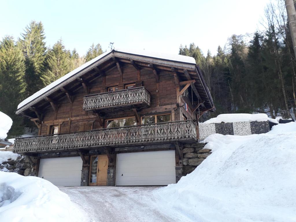 a log cabin with two garage doors in the snow at chalet le plan du rtia in Morzine