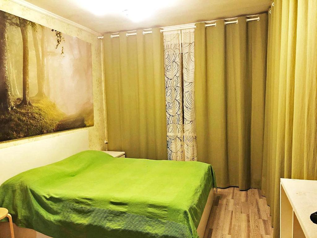 モスクワにあるApartment Hanaka Federativniy 43のベッドルーム(緑のベッド、カーテン付)