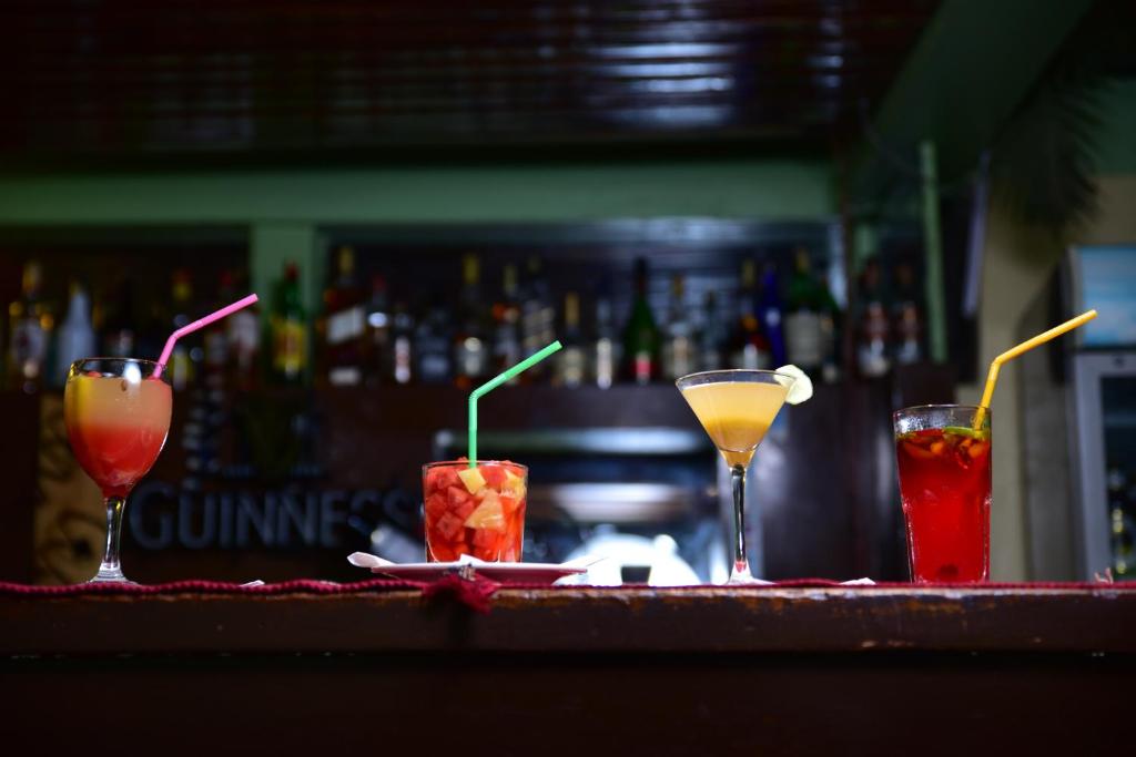a bar with three cocktails on a table at Masai Lodge in Nairobi
