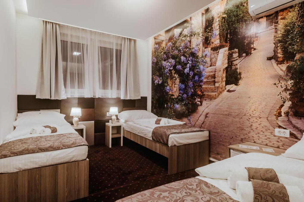 a hotel room with two beds and a mural at Hotel & Spa Villa Meydan in Mostar