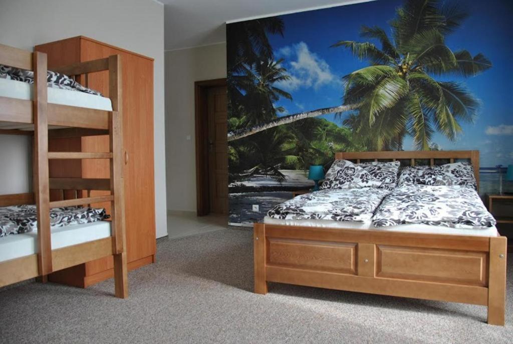 a bedroom with two bunk beds and a palm tree mural at Wiktoria-Biały Domek in Jastrzębia Góra
