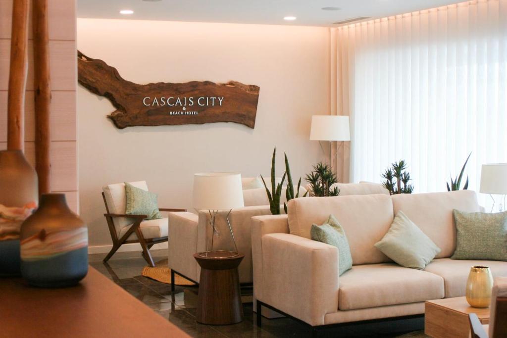 una sala de estar con sofá y un cartel en la pared en Cascais City & Beach Hotel, en Cascais