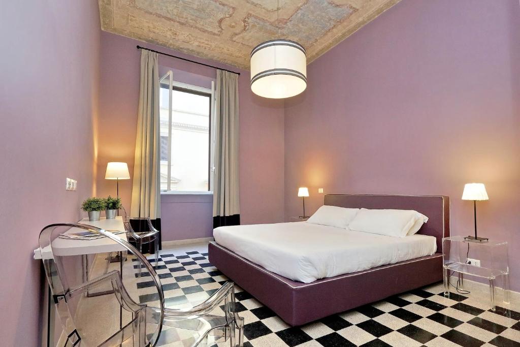 ein lila Schlafzimmer mit einem Bett und einem Glastisch in der Unterkunft Monti Apartments - My Extra Home in Rom