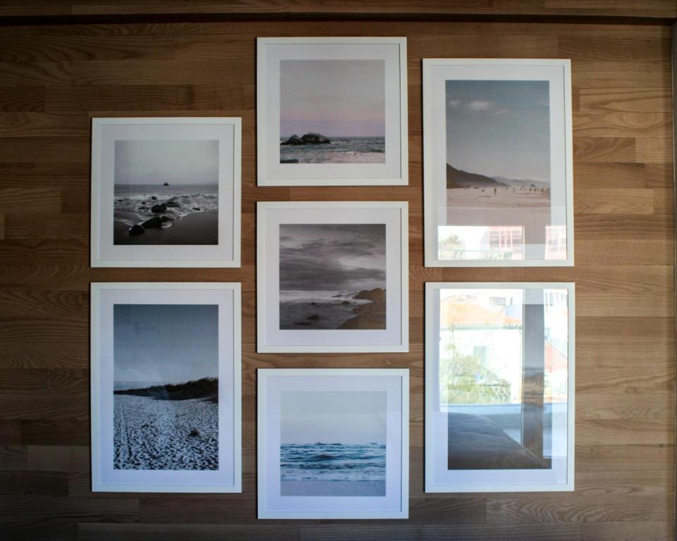 a group of framed pictures on a wall at Cascais City & Beach Hotel in Cascais