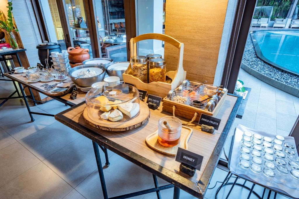 A breakfast station with tea, coffee, cereal, fruit and spreads beside the pool.