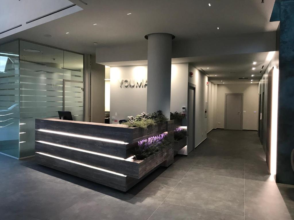 a lobby with a reception desk with purple flowers at YOUMAMI Suite Hotel Wellness&Spa in Giulianova