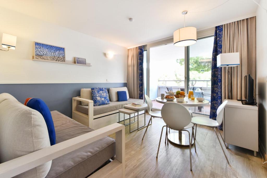a living room with a couch and a table at Résidence Pierre & Vacances Premium Port Prestige in Antibes
