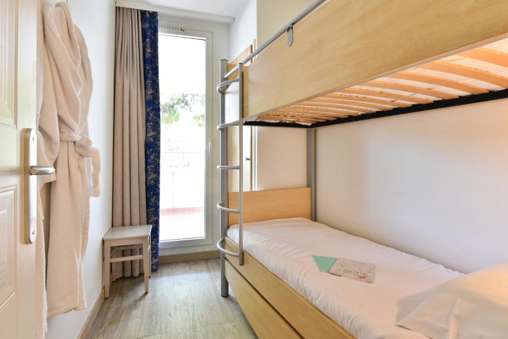 a bedroom with two bunk beds and a window at Résidence Pierre & Vacances Premium Port Prestige in Antibes