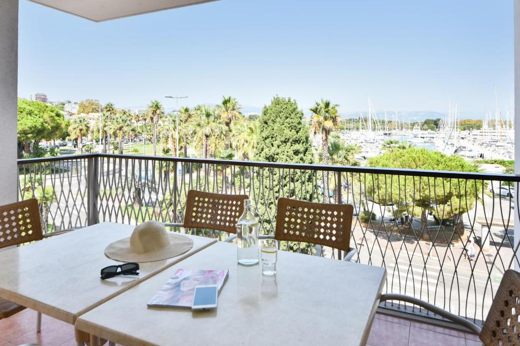 a table with a hat sitting on top of a balcony at Résidence Pierre & Vacances Premium Port Prestige in Antibes