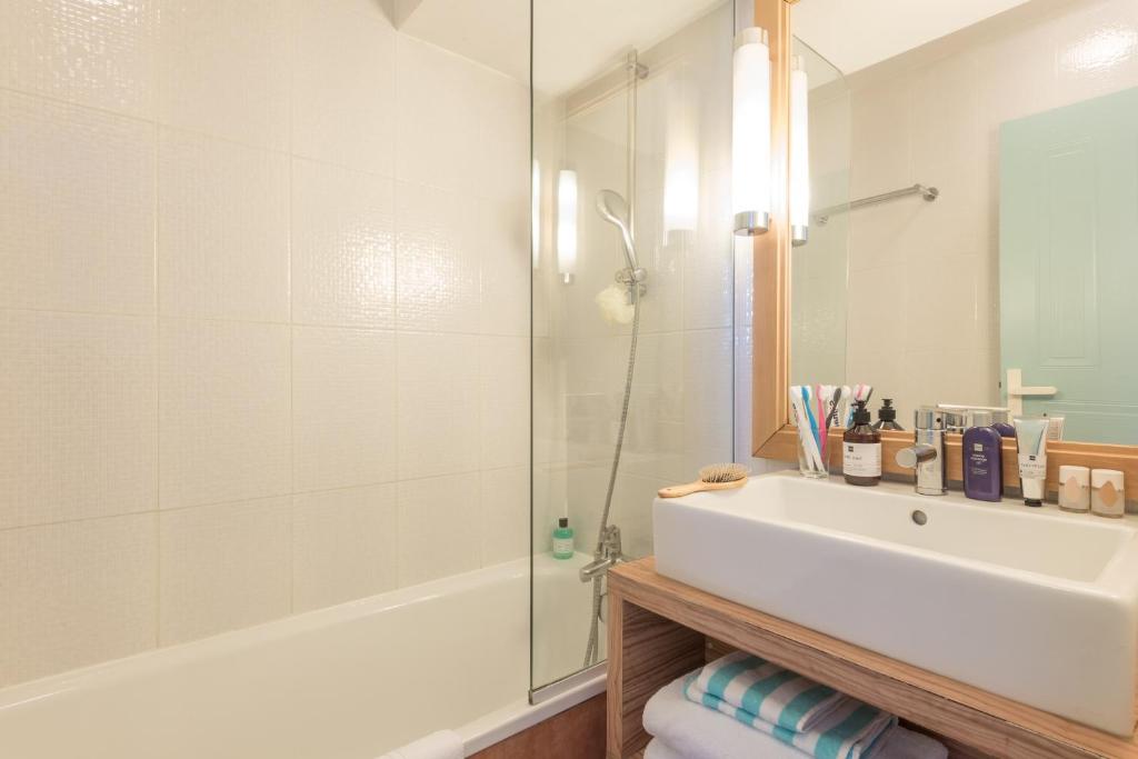 a bathroom with a tub and a sink and a shower at Résidence Pierre & Vacances Premium Port Prestige in Antibes