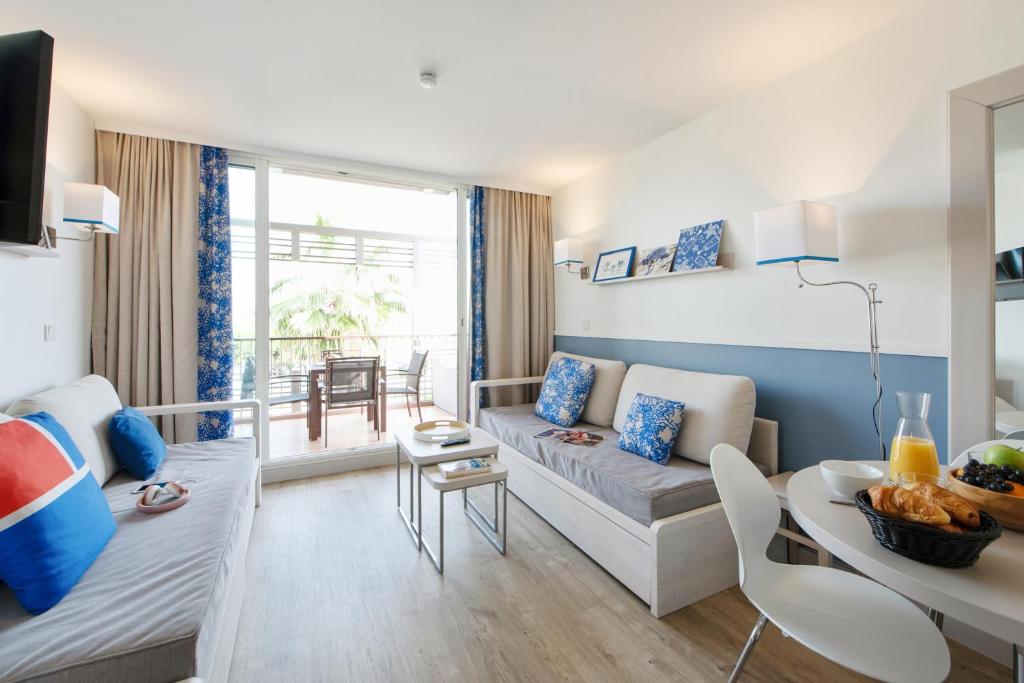 a living room with a couch and a table at Résidence Pierre & Vacances Premium Port Prestige in Antibes