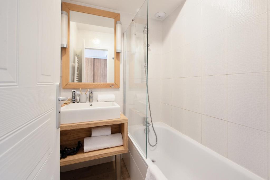 a bathroom with a sink and a tub and a shower at Résidence Pierre & Vacances Premium Port Prestige in Antibes