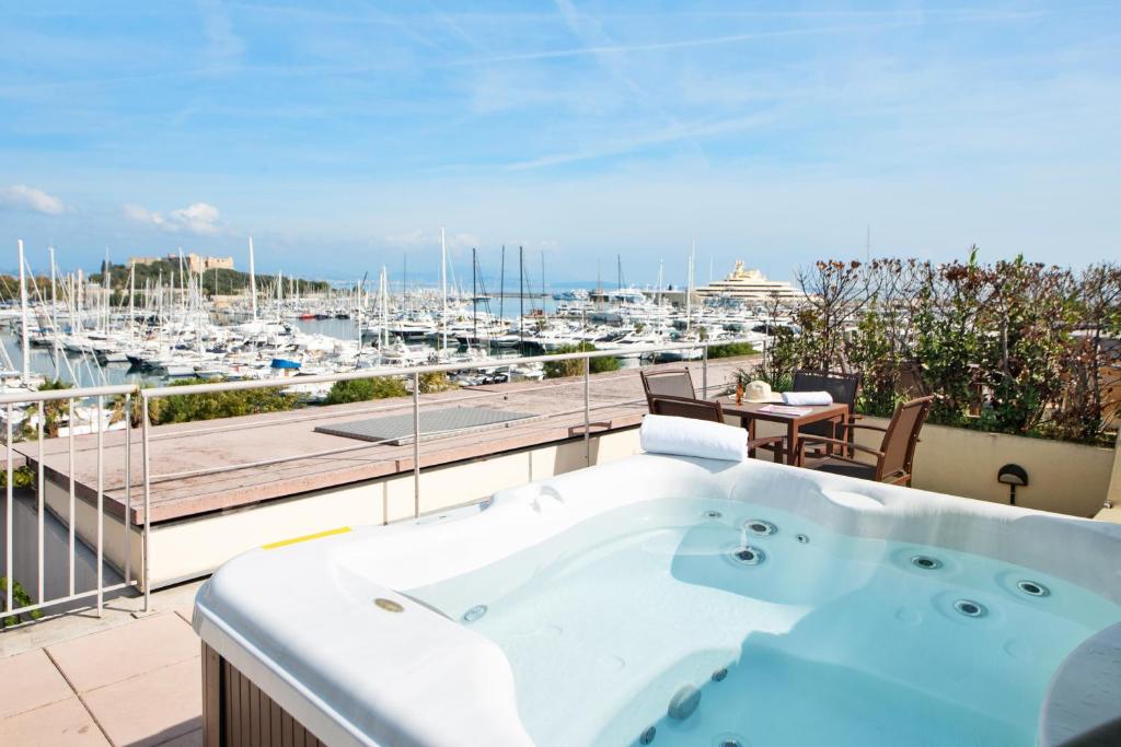 a hot tub on a balcony with a view of a marina at Résidence Pierre & Vacances Premium Port Prestige in Antibes