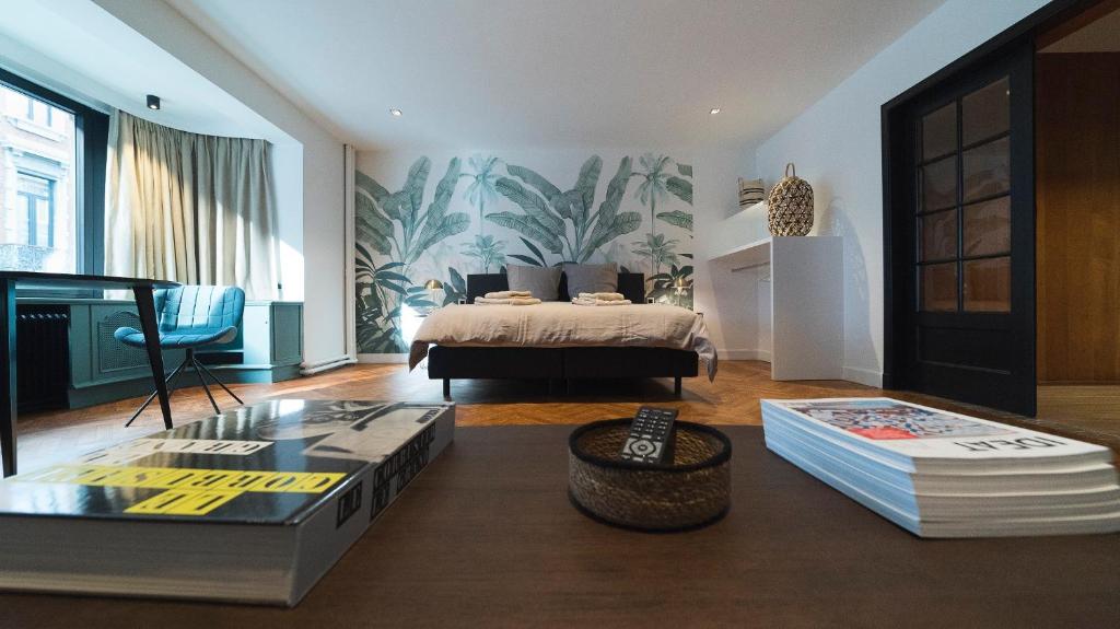 a bedroom with a bed and a table with books at B&B The Street Lodge in Liège