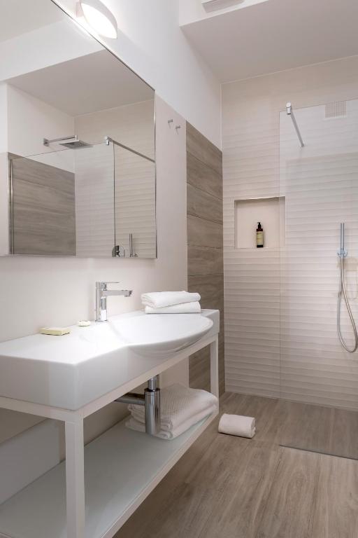 a white bathroom with a sink and a mirror at YOUMAMI Suite Hotel Wellness&Spa in Giulianova