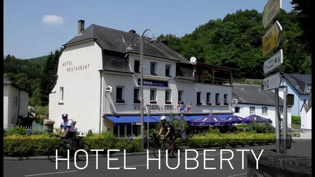 a hotel hudley with a sign in front of it at Hotel Huberty Kautenbach in Kautenbach