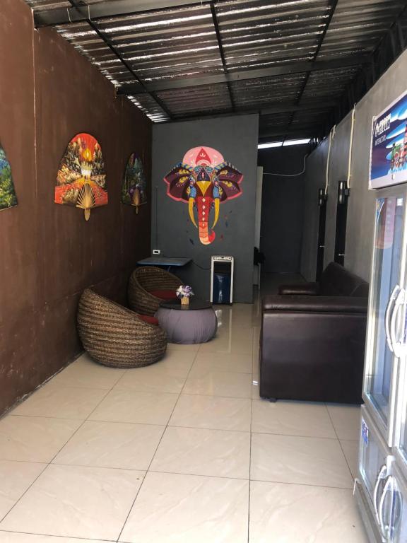 een woonkamer met een bank en een schilderij aan de muur bij BP cheap private rooms in Ko Mak