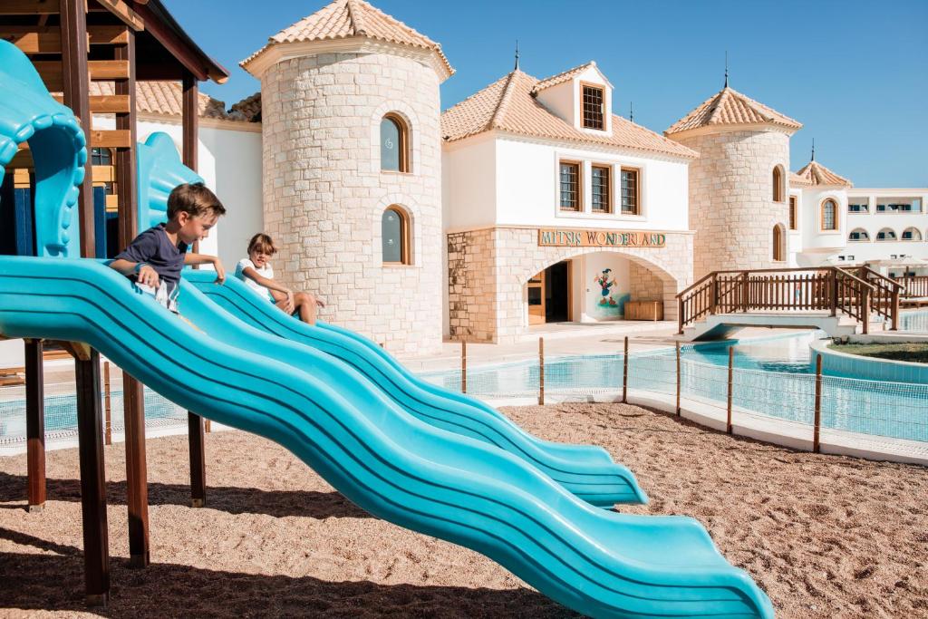 two children playing on a slide at a water park at Mitsis Selection Blue Domes in Kardamaina
