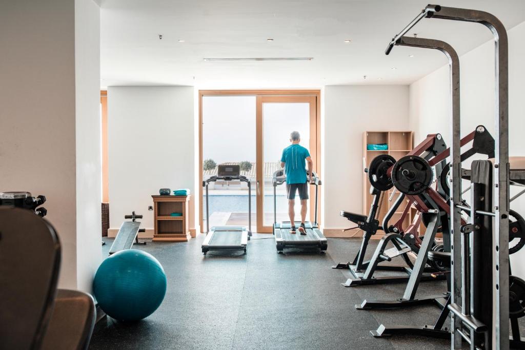 a man standing in a gym looking out the window at Mitsis Selection Blue Domes in Kardamaina