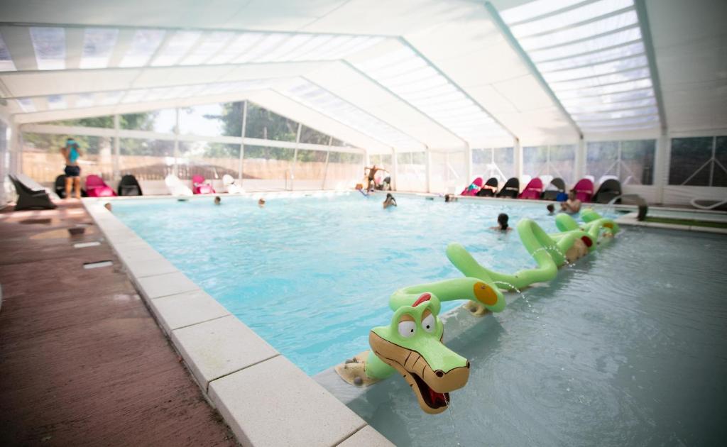 une grande piscine avec de nombreuses personnes dans l'établissement Camping La Belle Etoile, à Melun