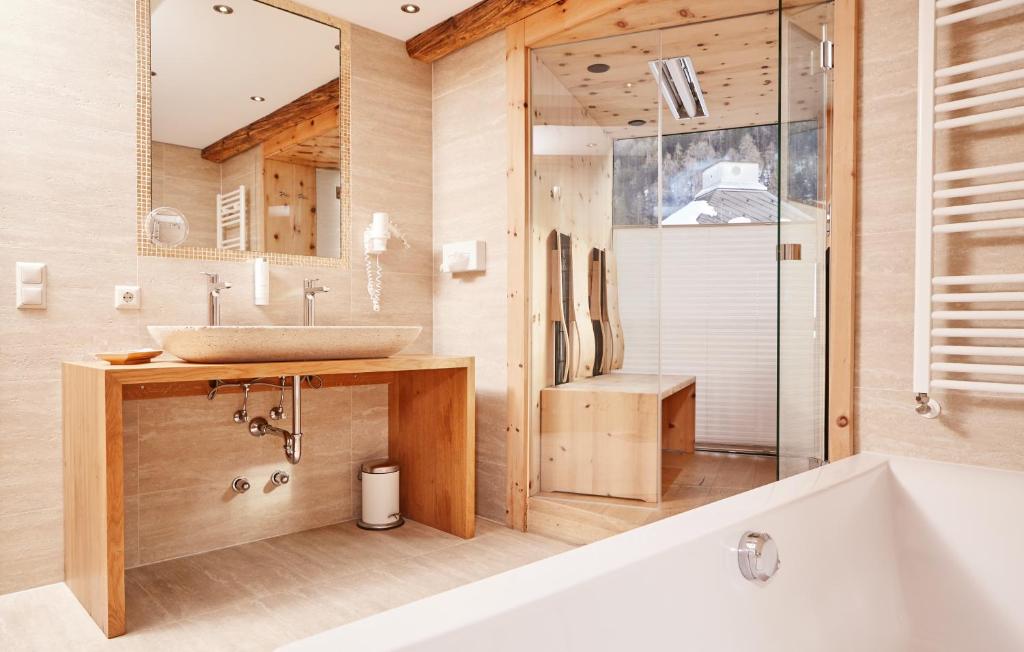 a bathroom with a tub and a sink and a shower at Hundehotel Riederhof in Ried im Oberinntal
