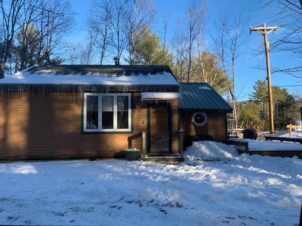 a small house with a door in the snow at Brook Road Cabin in Goshen