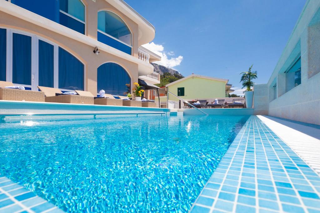 a swimming pool in front of a building at Apartments Ela in Makarska